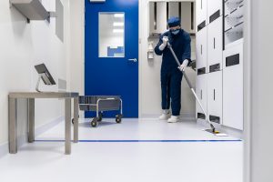 Cleanroom operator mopping the floor of a sterile room