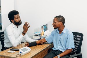 A doctor and a patient talking across a desk in a clinic